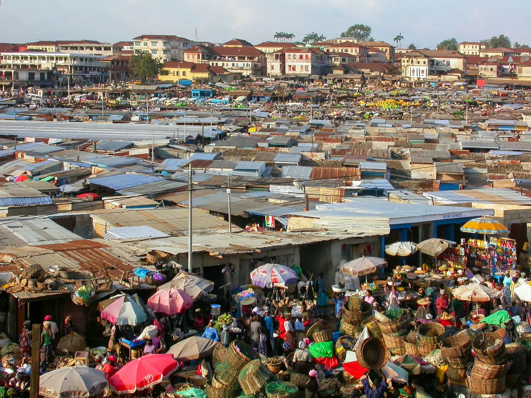 An aerial view of a crowded market with umbrellas and stalls